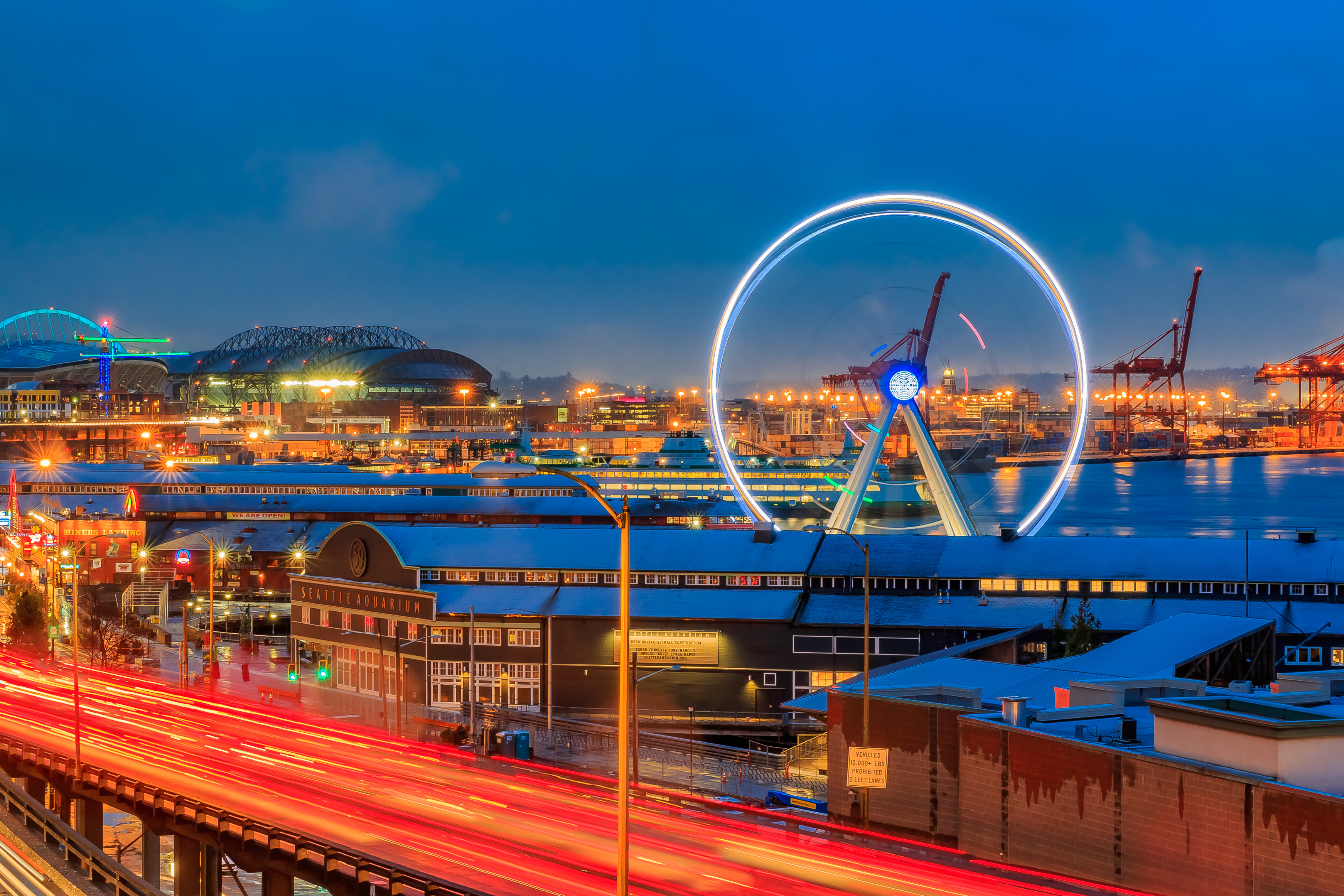 Seattle waterfront at sunset with Great Wheel and trail lights